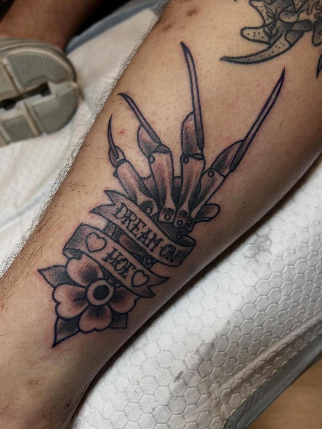 A color horror glove tattoo with a lettering banner