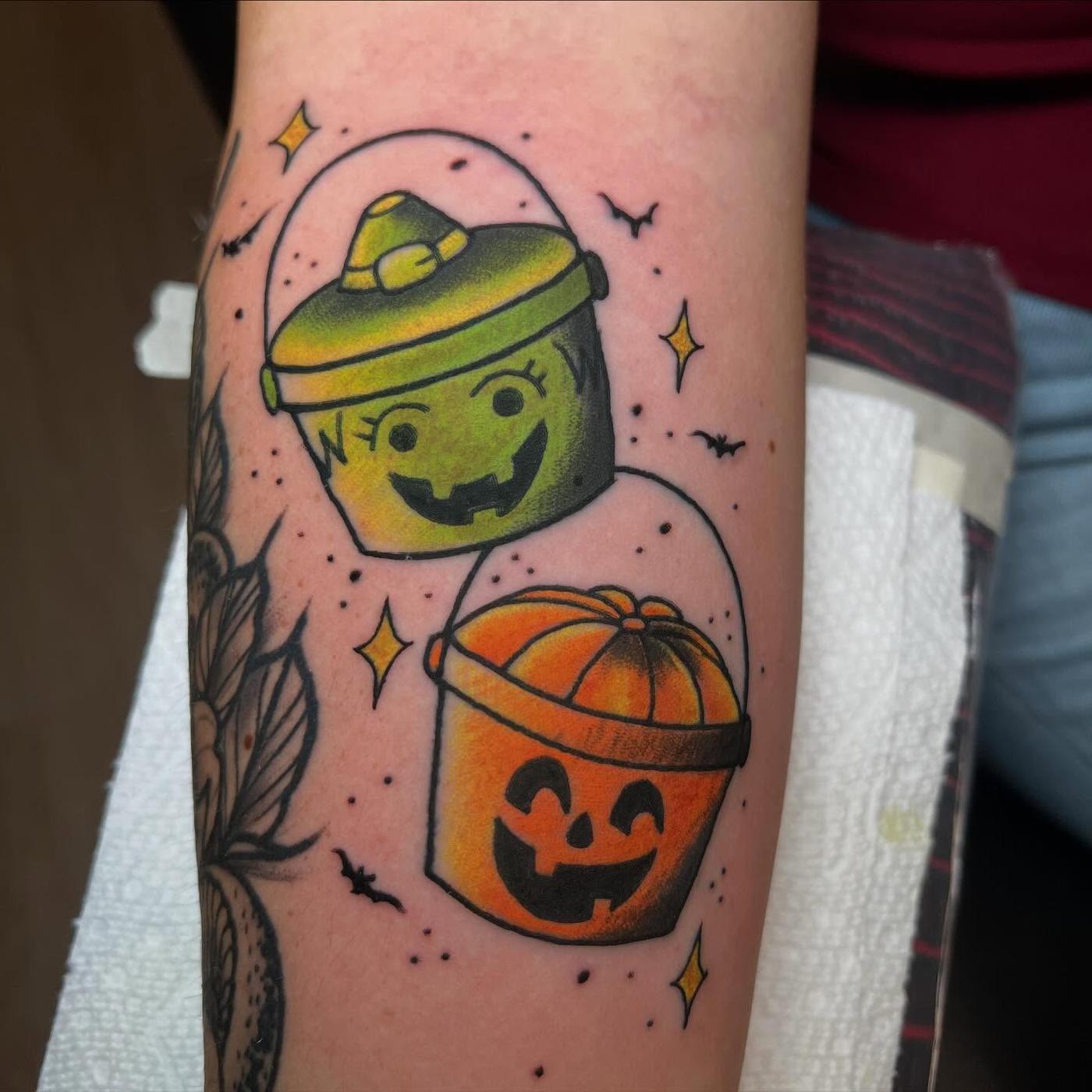 A color tattoo of two Halloween candy pails