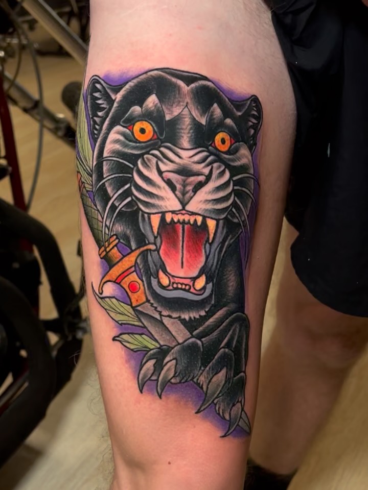 A color neo-traditional panther tattoo on a thigh