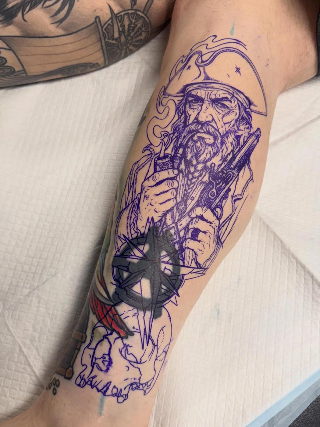 A purple stencil laid out on a leg before tattooing begins