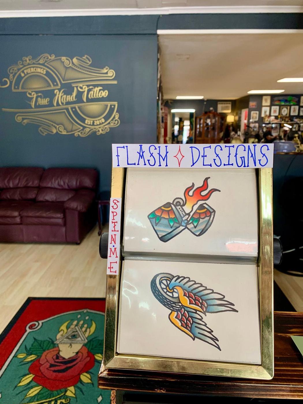 Hand-painted flash designs displayed on a board in the shop