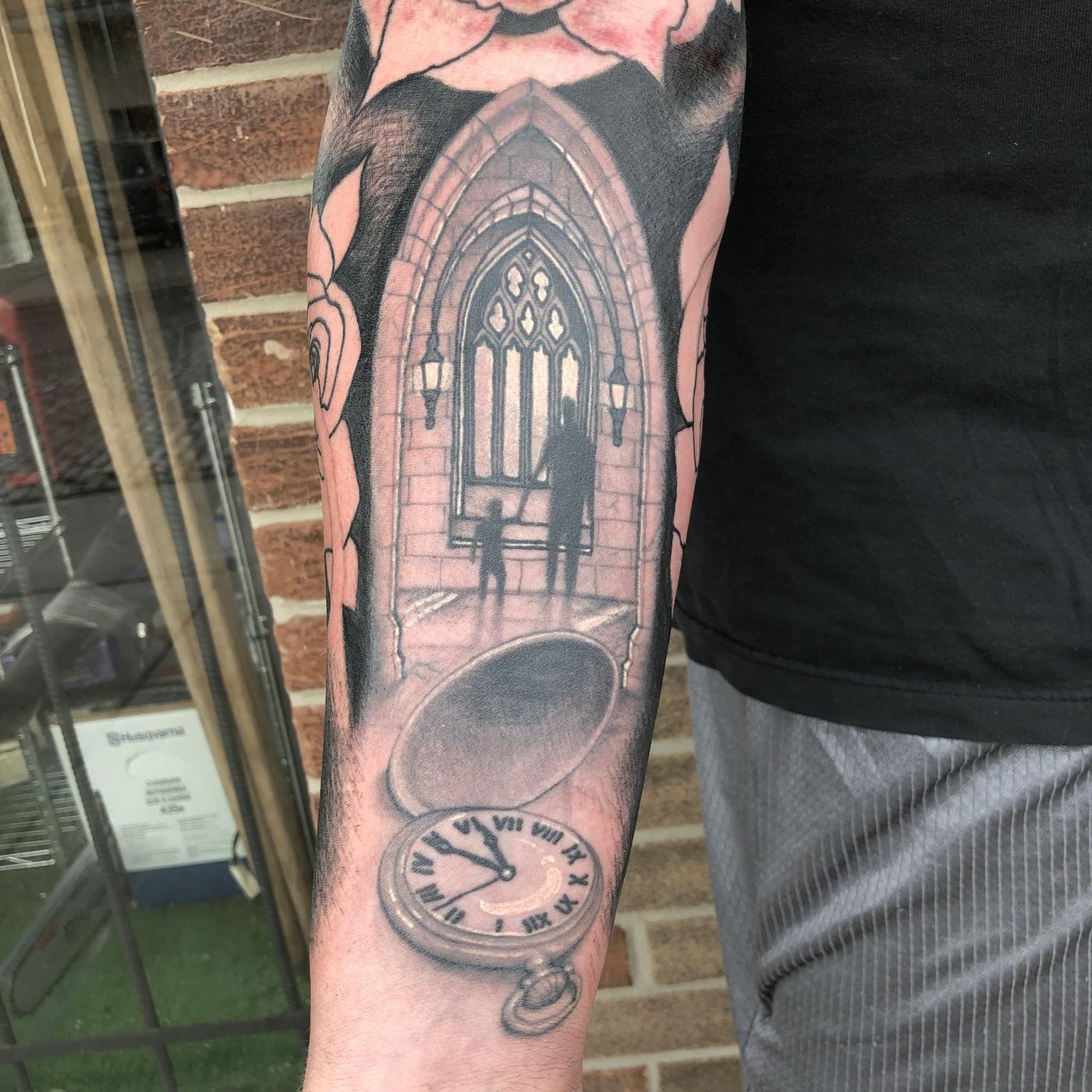 A black and gray realism cathedral interior and pocket watch forearm tattoo