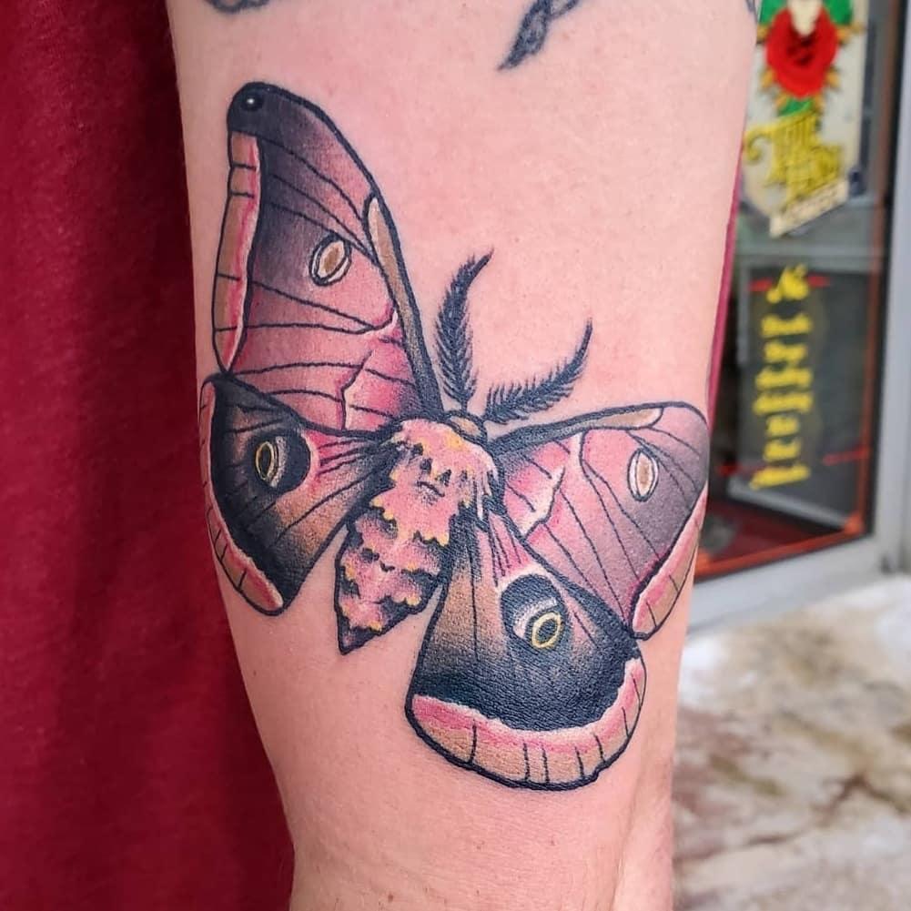 A color moth tattoo on an arm