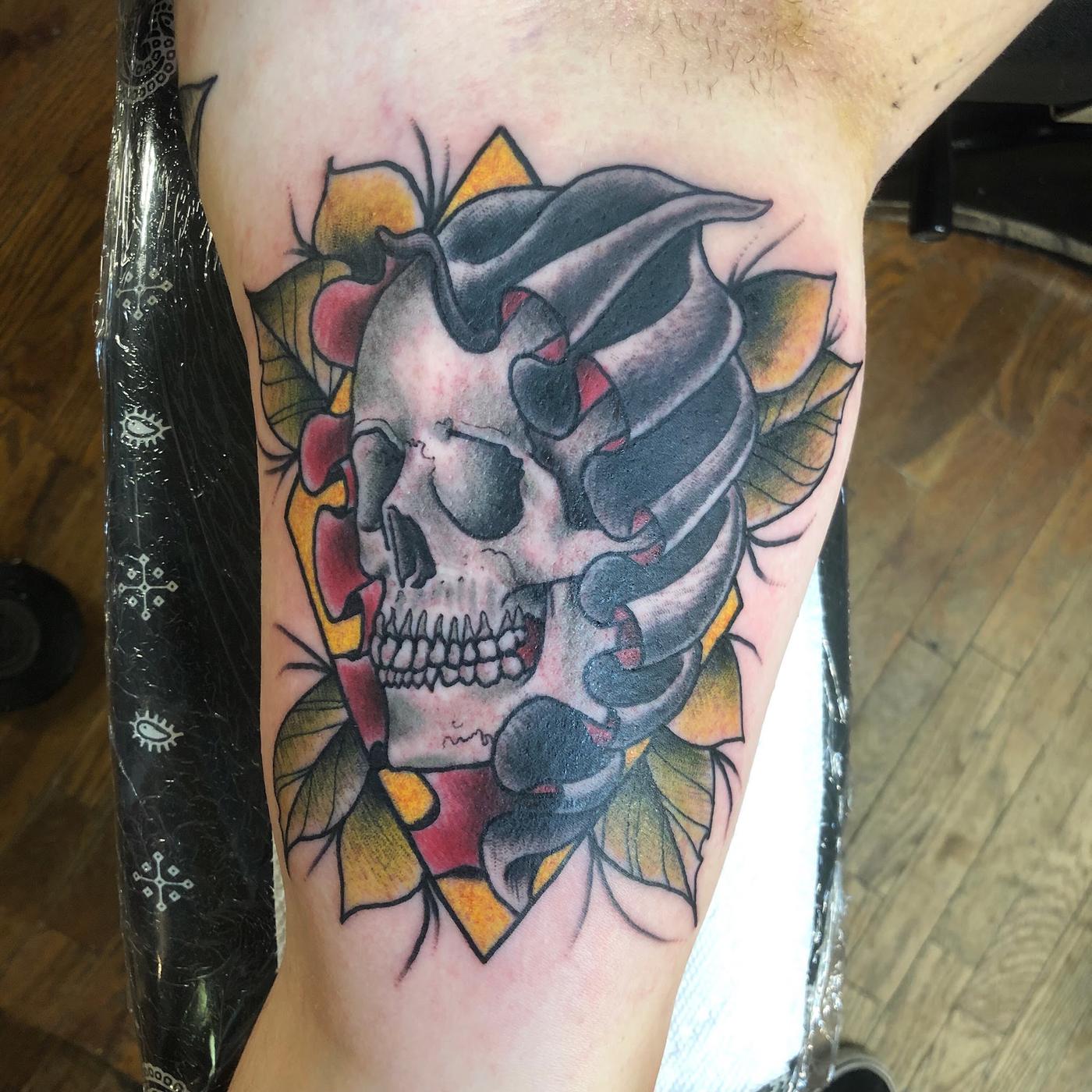 A color neo-traditional skull and playing cards tattoo